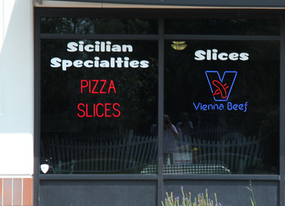 <b>SpellBrite Used as a Business Sign</b><br>SpellBrite helps sell pizza by the slice at this and other restaurants.<br><i>(SpellBrite Red letters used – the intense brightness of the red letters can make them look white/ or orange in photos.)</i>